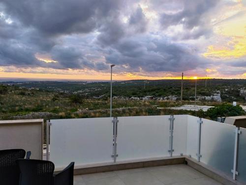 uma vista para o pôr-do-sol a partir da varanda de um edifício em Garden Relax Suites em Ispica