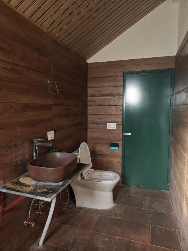 a bathroom with a toilet and a sink and a tub at Meraki Cottage in Darjeeling