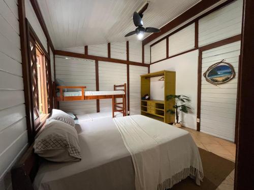 een slaapkamer met een bed en een bureau erin bij Pousada Nalu - Camburi in São Sebastião