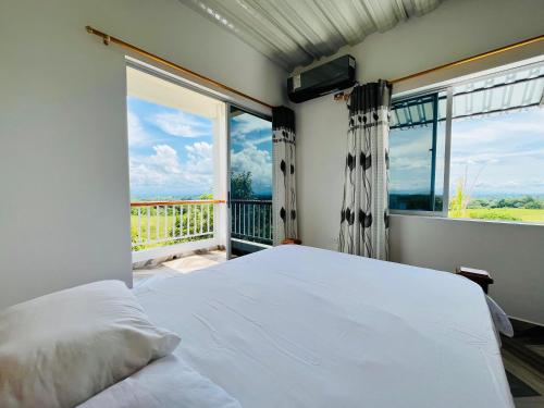 een slaapkamer met een bed en een groot raam bij Finca Casa Blanca in Doradal