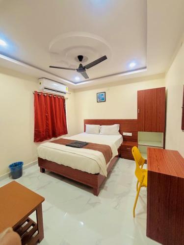 a bedroom with a bed and a table and a desk at RI Krishna Residency in Visakhapatnam