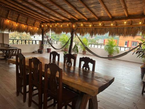 a wooden table and chairs in a room at Posada El Mágico in Mazunte