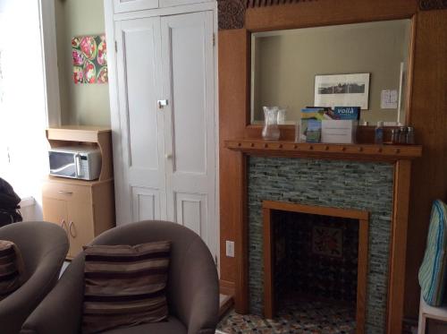 a living room with a fireplace and a mirror at Auberge St-Louis in Quebec City