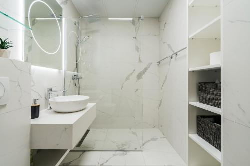 a white bathroom with a sink and a mirror at The View - Apartment with Pool in Blizikuće