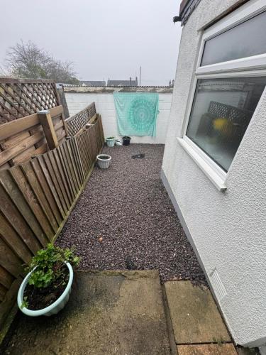 a backyard with a fence and a plant in a pot at Rosemary Cottage in Blaenavon