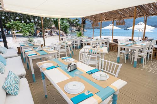 an outdoor restaurant with tables and chairs and the ocean at Hotel Pavlou in Poros