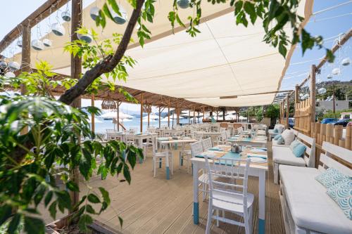 a restaurant with tables and chairs and a view of the ocean at Hotel Pavlou in Poros