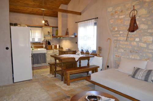 une cuisine et un salon avec un canapé et une table dans l'établissement AMPELOPETRA - Slow Country Living, à Ioannina