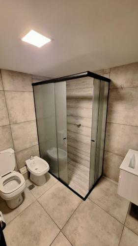 a bathroom with a toilet and a shower and a sink at Dpto Amoblado in Villa María