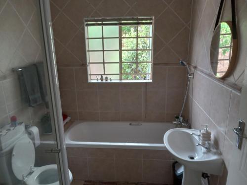 een badkamer met een ligbad en een wastafel bij Nested at L&MX in Centurion