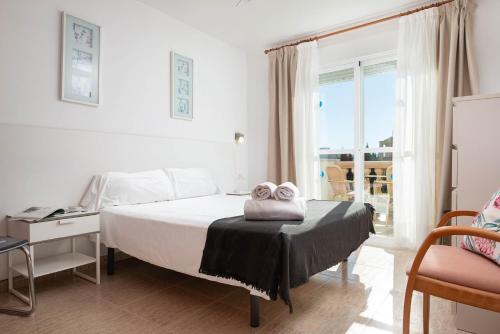 a bedroom with a bed with two towels on it at Villa El Olivo in Pollença
