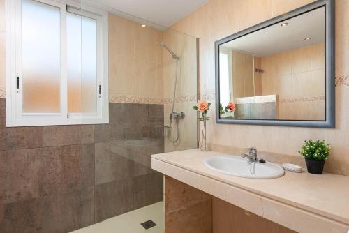 a bathroom with a sink and a shower with a mirror at Villa El Olivo in Pollença
