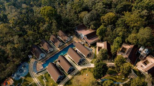 eine Luftaufnahme eines Hauses mit einem Fluss in der Unterkunft Golf Valley Luxury Resort Wayanad in Vythiri