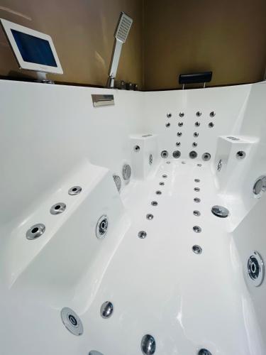 a bathtub in a room with a computer on the wall at Caprice Gruissanais Spa - T2 plage des chalets in Gruissan