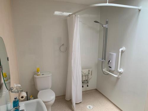 a white bathroom with a shower and a toilet at Glenerne 3 bedroom Cottage in Elgin
