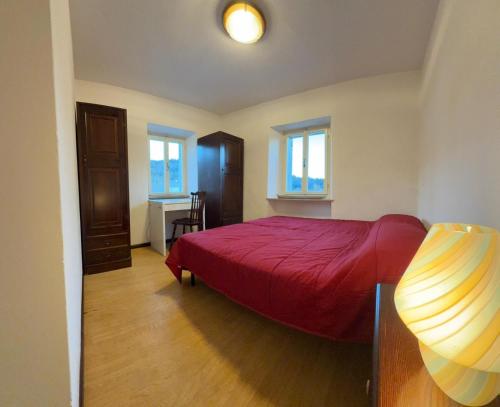 a bedroom with a red bed and a desk at Dimora Donato 2 bedrooms Lauco UD in Lauco
