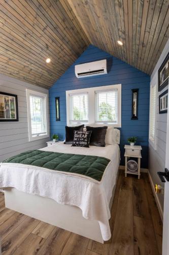 a bedroom with a large bed with blue walls at Hagrid's Hut - Harry Potter Riverfront Experience in New Richmond