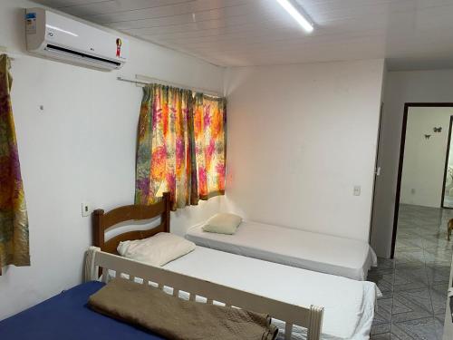 een kamer met twee bedden en een raam bij Casa no cumbuco in Caucaia