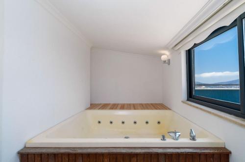 een badkuip in een badkamer met een raam bij Villa Vala in Kalkan