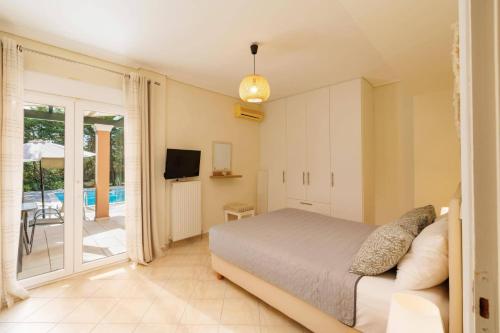 a bedroom with a bed and a balcony with a pool at Villa Elea Corfu by Villa Plus in Paleokastritsa