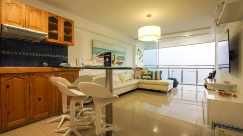 eine Küche und ein Wohnzimmer mit Tisch und Stühlen in der Unterkunft Edificio Sir William - Punta hermosa - Lima, Peru in Punta Hermosa