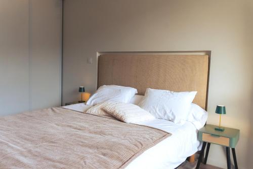 een slaapkamer met een groot bed met witte lakens en kussens bij Kj Homes in Prénatier