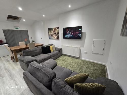 een woonkamer met banken en een flatscreen-tv bij Room 2 Shared House in L7 in Liverpool