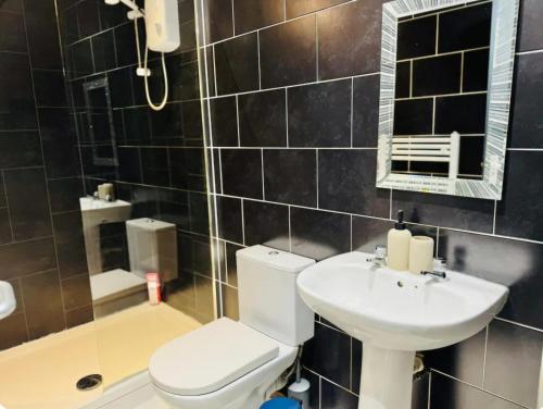 een badkamer met een toilet, een wastafel en een spiegel bij Room 2 Shared House in L7 in Liverpool
