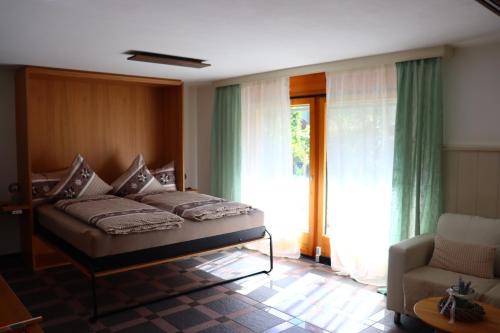 a bedroom with a bed and a chair and a window at Ferienwohnung an der Seez in Mels