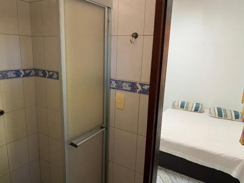een badkamer met een douche en een bed in een kamer bij Casa no cumbuco in Caucaia