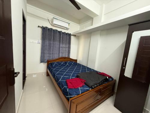 een kleine slaapkamer met een bed met blauwe lakens bij TVK Grands 7 - Premium Two Bedroom Apartment in Coimbatore