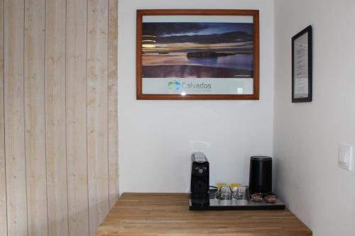 a room with a picture on the wall and a table at Domaine Des Piéris - Chambres d'Hôtes in Grandcamp-Maisy