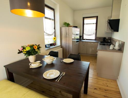 a small kitchen with a wooden table and a dining room at Haus zur Pulvermühle in Zwenkau