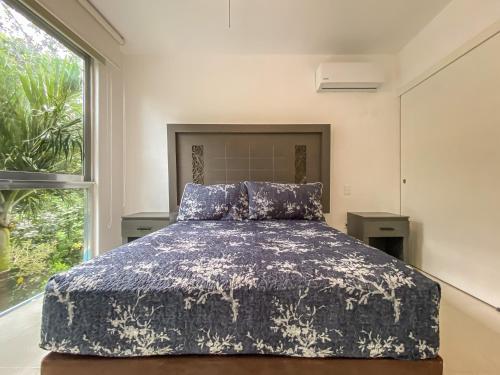 a bedroom with a bed and a large window at Oceanblue by Andiani Travel in Playa del Carmen