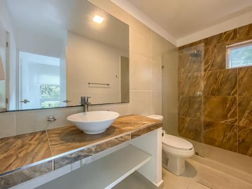 a bathroom with a sink and a toilet at Oceanblue by Andiani Travel in Playa del Carmen