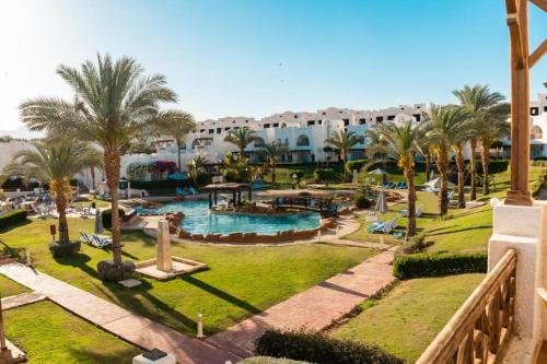 a resort with a pool and palm trees and buildings at Jaz Sharm Dream Vacation Club Time Share - Reservation only on Saturdays - Min stay 7 Days in Sharm El Sheikh