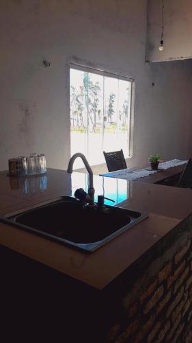 een keuken met een spoelbak en een aanrechtblad bij Casa dunas in Guajiru