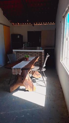 een houten tafel en stoelen in een kamer met een raam bij Casa dunas in Guajiru