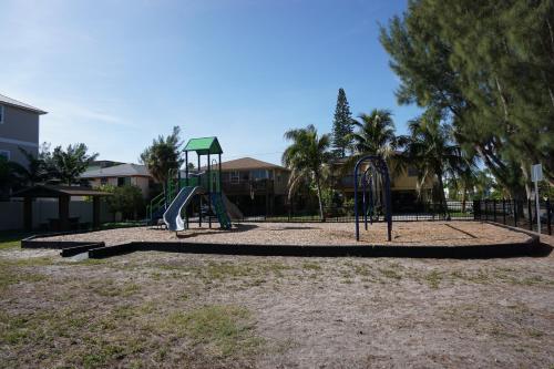 a playground with a slide in a park at Anna Maria Island Tree House in Bradenton Beach