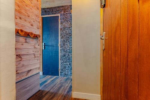 een hal met een blauwe deur en een bakstenen muur bij Cosy 5 persons / Ski In Ski out in Val Thorens