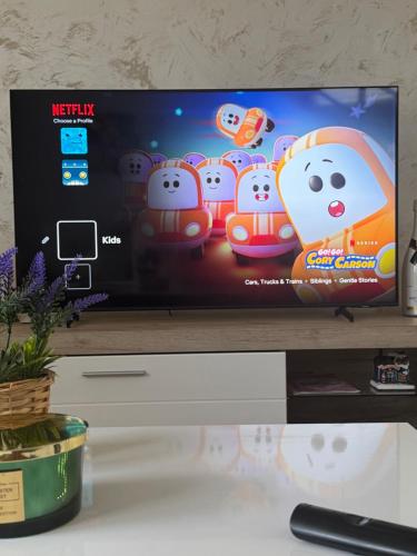 a flat screen tv sitting on top of a table at Apartman LUX Jelena in Surčin