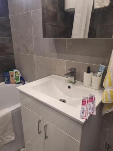 a bathroom with a white sink and a tub at Apartman LUX Jelena in Surčin