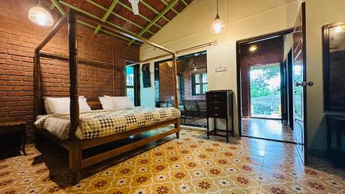 a bedroom with a bed and a brick wall at Green Roots Farm Stay, Shahapur in Shāhāpur