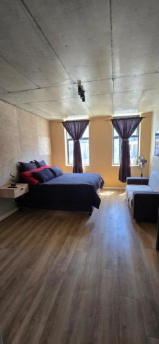 a large bedroom with two beds and two windows at Ebbies place in Cape Town