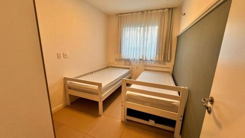 una piccola stanza con due letti e una finestra di Beach Way Porto das Dunas ad Aquiraz
