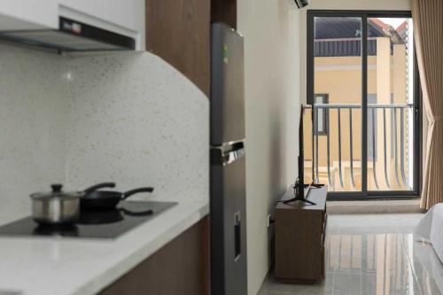 a kitchen with a stove top oven next to a window at Collection O West Lake Apartment in Hanoi