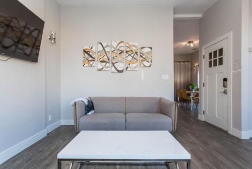 a living room with a couch and a table at Prime Location! - 1min Walk to Wrigley Field - Modern 2BR Apts Right Next to Wrigley Field & Transit! in Chicago