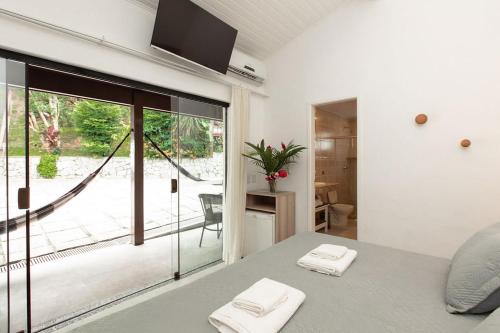 um quarto com uma cama e uma grande janela de vidro em Angra Boutique Hotel em Angra dos Reis