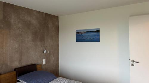 een slaapkamer met een bed en een schilderij aan de muur bij Ferienwohnung Passat in Olpenitzdorf in Olpenitzdorf