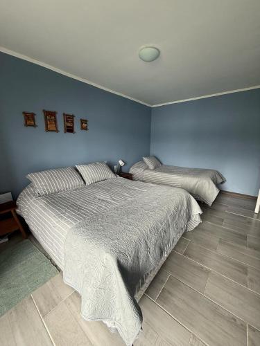 a bedroom with two beds and a blue wall at Casa Lago Rupanco in Puerto Rico